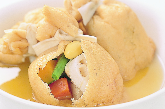 七福茶巾の惣菜イメージ。南瓜、人参、銀杏、蓮根、いんげん、大根、はんぺんの七つの「ん」がつく素材を茶巾に包んだ縁起の良い一品