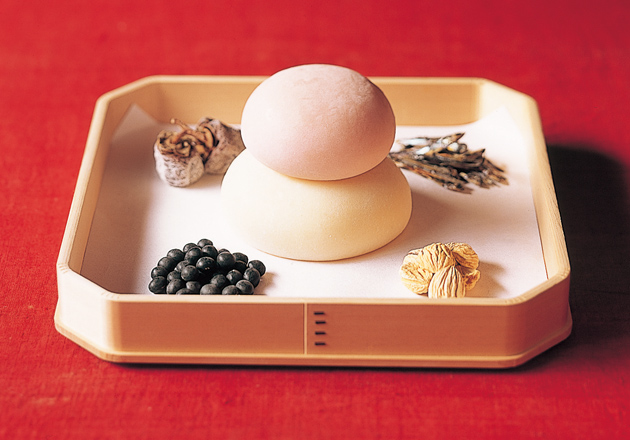 お正月の季節の室礼を表すイメージビジュアル。鏡餅を中心に黒豆や柿などの縁起物を配した、迎春の静かな設え